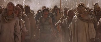 Movie still from “Stargate” (1994), directed by Roland Emmerich – A group of people walking through a crowd of people; Wide shot, High angle