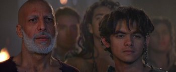 Movie still from “Stargate” (1994), directed by Roland Emmerich – A group of people standing in front of a wall; Close Up shot, Over the shoulder angle