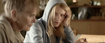 A woman with blonde hair wearing a hooded sweatshirt