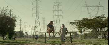 A man and woman sitting on top of a wooden bench