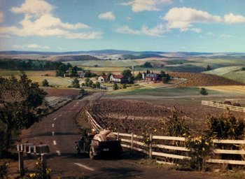 Movie still from “State Fair” (1945), directed by Walter Lang – A car is parked on the side of the road near a field; Extreme Wide shot, High angle