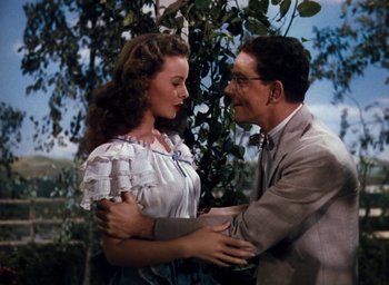 Movie still from “State Fair” (1945), directed by Walter Lang – A man and a woman holding each other in a forest; Medium shot, High angle
