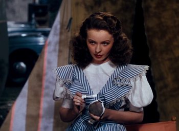 Movie still from “State Fair” (1945), directed by Walter Lang – A woman in a striped dress holding a camera in a room; Close Up shot, High angle