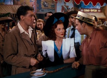 Movie still from “State Fair” (1945), directed by Walter Lang – A group of men standing around a woman; Medium shot, Over the shoulder angle