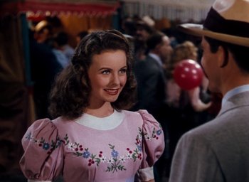 Movie still from “State Fair” (1945), directed by Walter Lang – A woman in a pink dress smiling at a crowd; Medium shot, Over the shoulder angle