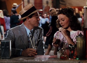 Movie still from “State Fair” (1945), directed by Walter Lang – A man and a woman sitting at a table with wine glasses; Medium shot, High angle