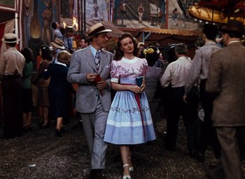 Movie still from “State Fair” (1945), directed by Walter Lang – A man and a woman are walking through a carnival; Medium shot, Low angle