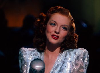 Movie still from “State Fair” (1945), directed by Walter Lang – A woman in a silver dress holding a microphone; Close Up shot, Low angle
