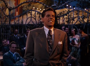 Movie still from “State Fair” (1945), directed by Walter Lang – A man wearing a suit and tie in front of an audience; Medium shot, Over the shoulder angle