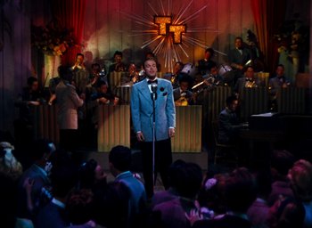 Movie still from “State Fair” (1945), directed by Walter Lang – A man standing in front of an audience holding a microphone; Extreme Wide shot, High angle