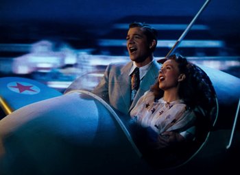 Movie still from “State Fair” (1945), directed by Walter Lang – A man and a woman riding in an amusement ride; Wide shot, Overhead angle