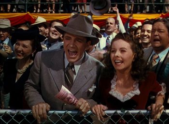 Movie still from “State Fair” (1945), directed by Walter Lang – A man and a woman in a crowd at a baseball game; Medium shot, Low angle