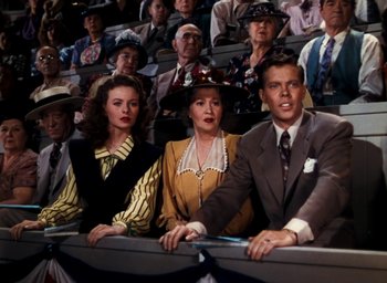 Movie still from “State Fair” (1945), directed by Walter Lang – A group of people sitting next to each other in an audience; Medium shot, High angle