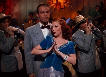 Movie still from “State Fair” (1945), directed by Walter Lang – A man and a woman are standing in front of a crowd; Medium shot, Low angle