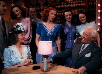 Movie still from “State Fair” (1945), directed by Walter Lang – A group of people standing around a table; Medium shot, High angle