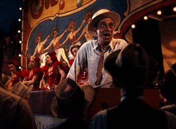 Movie still from “State Fair” (1945), directed by Walter Lang – A man in a hat and a striped shirt talking to a crowd; Medium shot, Low angle
