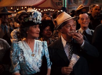 Movie still from “State Fair” (1945), directed by Walter Lang – An older man and a woman in a crowd of people; Medium shot, Low angle