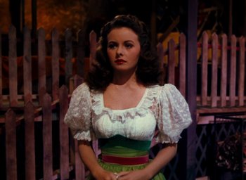 Movie still from “State Fair” (1945), directed by Walter Lang – A woman wearing a white blouse and green skirt; Medium shot, Over the shoulder angle