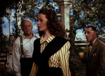 Movie still from “State Fair” (1945), directed by Walter Lang – A woman wearing a striped shirt and a black and yellow dress; Medium shot, Over the shoulder angle