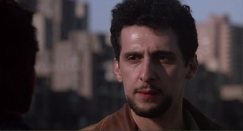 Movie still from “State of Grace” (1990), directed by Phil Joanou – A person wearing a brown jacket; Close Up shot, Low angle