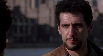 Movie still from “State of Grace” (1990), directed by Phil Joanou – A person wearing a brown jacket; Close Up shot, Low angle