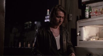 Movie still from “State of Grace” (1990), directed by Phil Joanou – A man with long hair wearing a leather jacket; Medium shot, Low angle