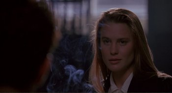 Movie still from “State of Grace” (1990), directed by Phil Joanou – A young woman is smoking a cigarette in front of a mirror; Close Up shot, Over the shoulder angle