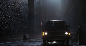 Movie still from “State of Grace” (1990), directed by Phil Joanou – A car driving down a street in the dark; Wide shot, Low angle