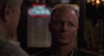 Movie still from “State of Grace” (1990), directed by Phil Joanou – A person wearing a suit and tie; Close Up shot, Low angle