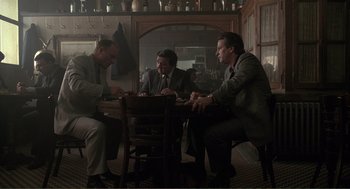 Movie still from “State of Grace” (1990), directed by Phil Joanou – A group of men sitting at a table in a room; Wide shot, High angle