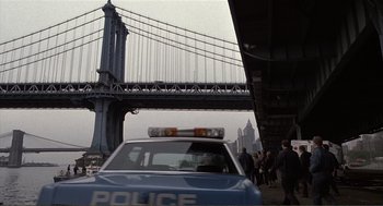 Movie still from “State of Grace” (1990), directed by Phil Joanou – A police car parked on the side of the road; Wide shot, Low angle