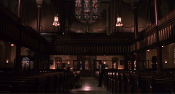 Movie still from “State of Grace” (1990), directed by Phil Joanou – A man standing inside of a large church; Extreme Wide shot, High angle