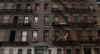 Movie still from “State of Grace” (1990), directed by Phil Joanou – A building with fire escapes on the side of the building; Extreme Wide shot, Overhead angle