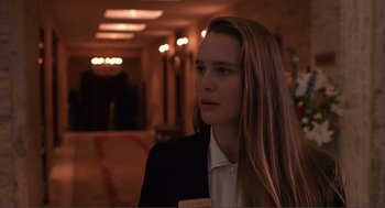 Movie still from “State of Grace” (1990), directed by Phil Joanou – A woman in a black jacket is standing in a room; Close Up shot, Over the shoulder angle