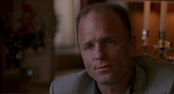 Movie still from “State of Grace” (1990), directed by Phil Joanou – A person wearing a suit and tie; Close Up shot, Low angle