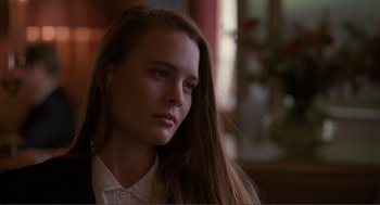Movie still from “State of Grace” (1990), directed by Phil Joanou – A woman with long brown hair wearing a white dress shirt; Close Up shot, Over the shoulder angle
