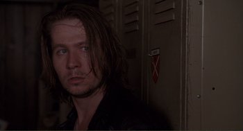 Movie still from “State of Grace” (1990), directed by Phil Joanou – A person with long brown hair; Close Up shot, Over the shoulder angle