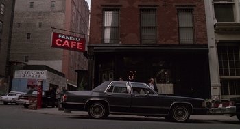 Movie still from “State of Grace” (1990), directed by Phil Joanou – A car parked in front of a building on a street; Wide shot, Low angle