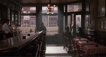 Movie still from “State of Grace” (1990), directed by Phil Joanou – People are sitting at a bar in a dimly - lit restaurant; Wide shot, High angle