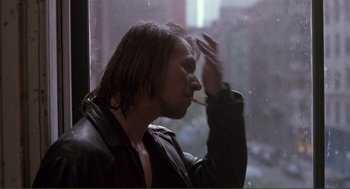 Movie still from “State of Grace” (1990), directed by Phil Joanou – A man smoking a cigarette while looking out a window; Close Up shot, Over the shoulder angle