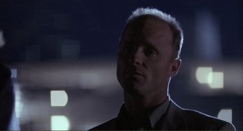 Movie still from “State of Grace” (1990), directed by Phil Joanou – A person wearing a suit and tie; Close Up shot, Low angle