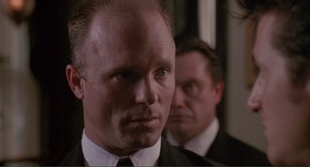 Movie still from “State of Grace” (1990), directed by Phil Joanou – A man in a suit and tie next to another man in a suit and tie; Close Up shot, Low angle