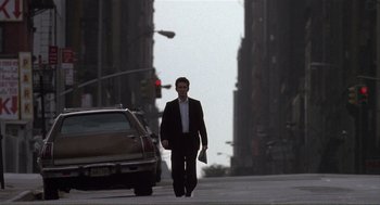 Movie still from “State of Grace” (1990), directed by Phil Joanou – A man walking down the street in a business suit; Wide shot, Low angle