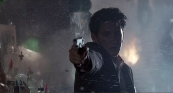 Movie still from “State of Grace” (1990), directed by Phil Joanou – A man is holding a gun in the dark; Close Up shot, Low angle