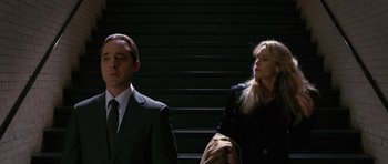 Movie still from “State of Play” (2009), directed by Kevin Macdonald – A man and a woman standing next to each other on some steps; Medium shot, Low angle
