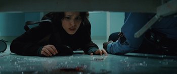 Movie still from “State of Play” (2009), directed by Kevin Macdonald – A woman laying on the ground with a knife in her hand; Medium shot, Low angle