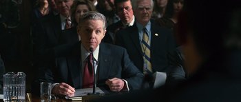 Movie still from “State of Play” (2009), directed by Kevin Macdonald – A group of people in suits and ties sitting at a table; Medium shot, Over the shoulder angle
