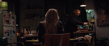 Movie still from “State of Play” (2009), directed by Kevin Macdonald – A woman with long blonde hair sitting at a table; Medium shot, Over the shoulder angle