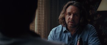 Movie still from “State of Play” (2009), directed by Kevin Macdonald – A man with long hair sitting in front of a window; Close Up shot, Over the shoulder angle