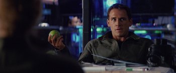 Movie still from “Stealth” (2005), directed by Rob Cohen – A man holding an apple sitting at a table; Close Up shot, Over the shoulder angle